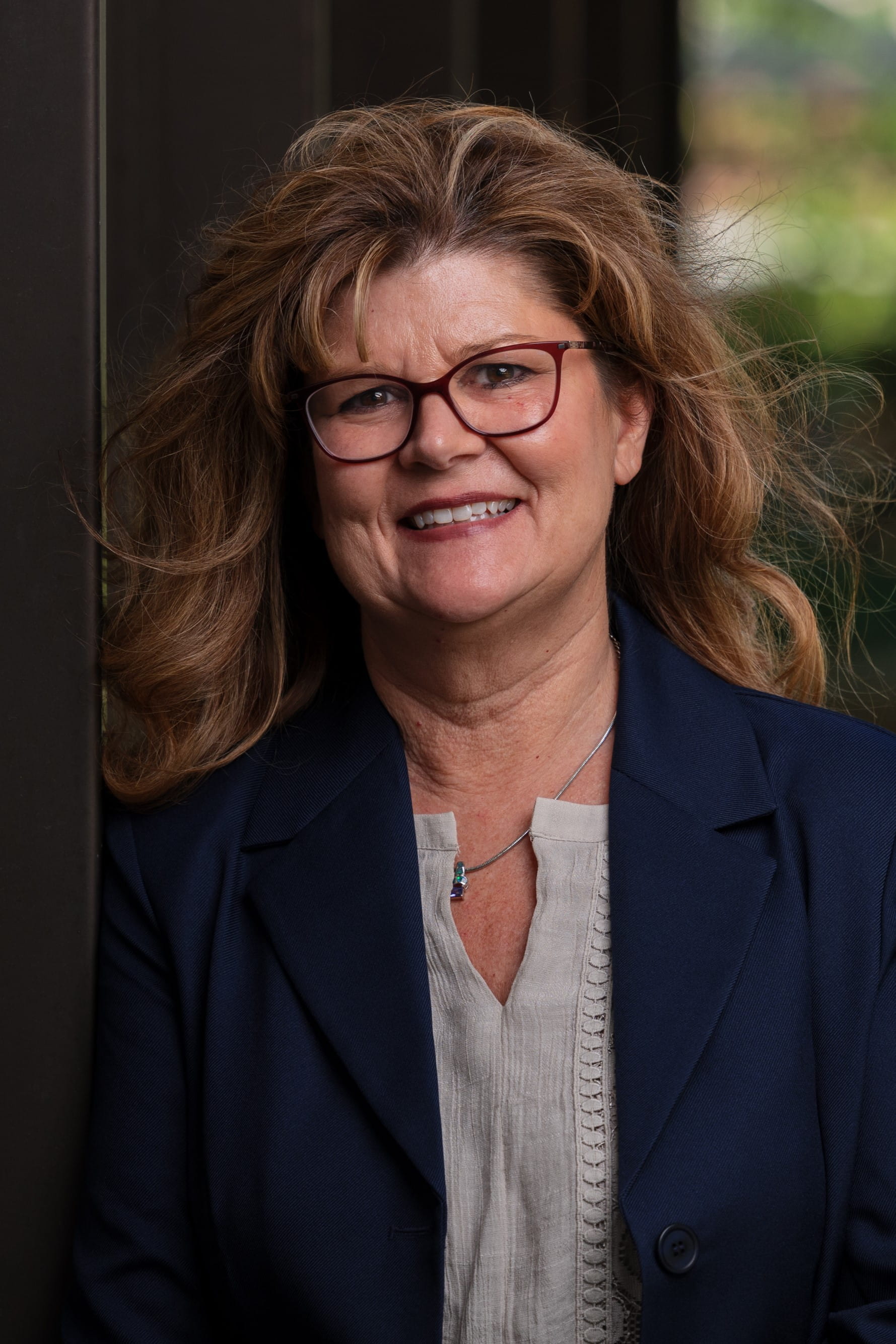 Shannon McDaniel wearing glasses, long light brown hair and a black jacket over white blouse.