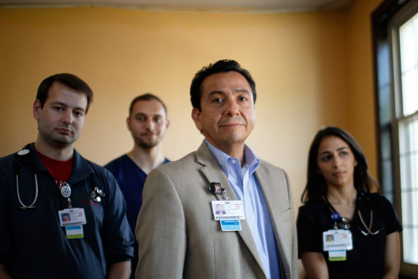 four members of the student outreach clinic stand together with powerful expressions wearing their medical ID badges