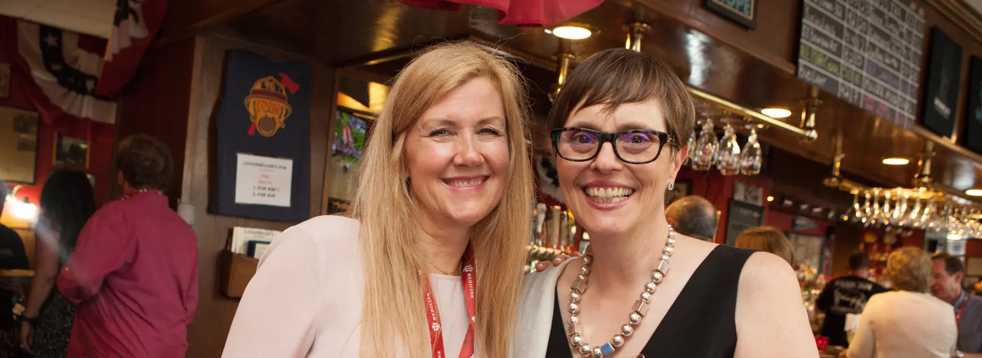 alumni smile widely for a photo at an event