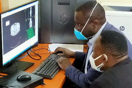 Two men examine an image on a computer screen. 