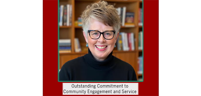 Dr. Newton sits in front of a bookshelf 