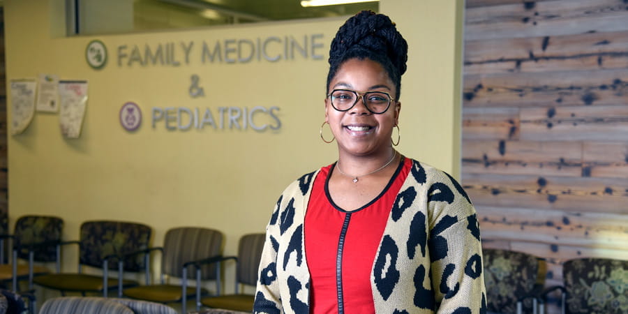 LaTasha Timberlake stands in front of the clinic waiting room