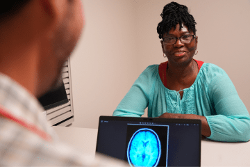 a woman smiles while she speaks to her doctor
