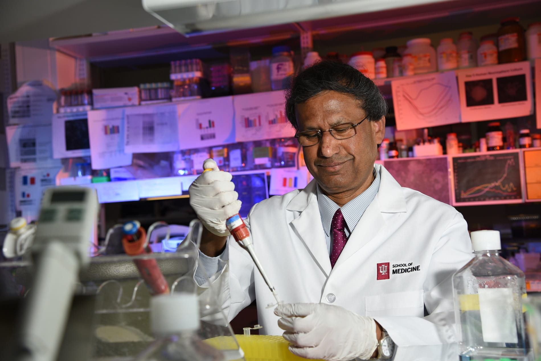 Deb Lahiri works with a pipette in his lab at IU School of Medicine.