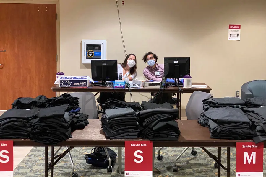 Ashton Moody and Bilal Jawed volunteer at a scrub station at Ball Memorial Hospital