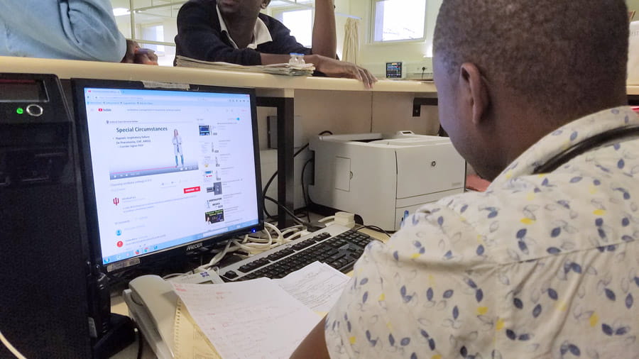 A doctor in Botswana watches a video on ventilators produced by Dr. Graham Carlos and Dr. Kara Goss