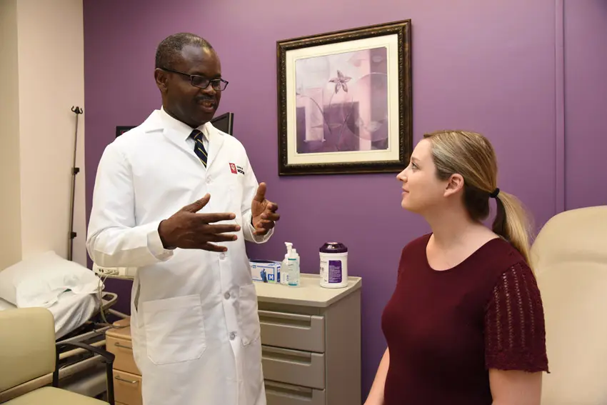 Dr. Method Tuuli speaks to a patient in the ob-gyn clinic