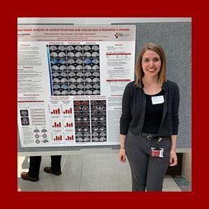 emily stands in front of her research poster