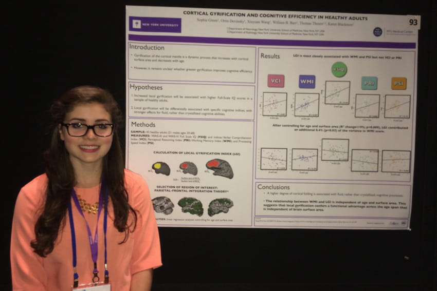 Green poses with a research poster she worked on during college at NYU