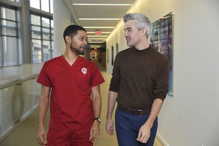 Psychiatry resident, Dustin Nowaskie, MD and IU nursing student, Jared Riley, walking in Goodman Hall.