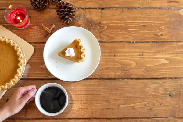 pumpkin pie and person holding cup of coffee 
