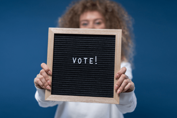 Woman holding up sign that says Vote!