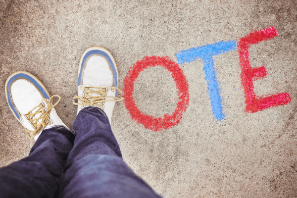 Two feet forming V with chalk of word VOTE