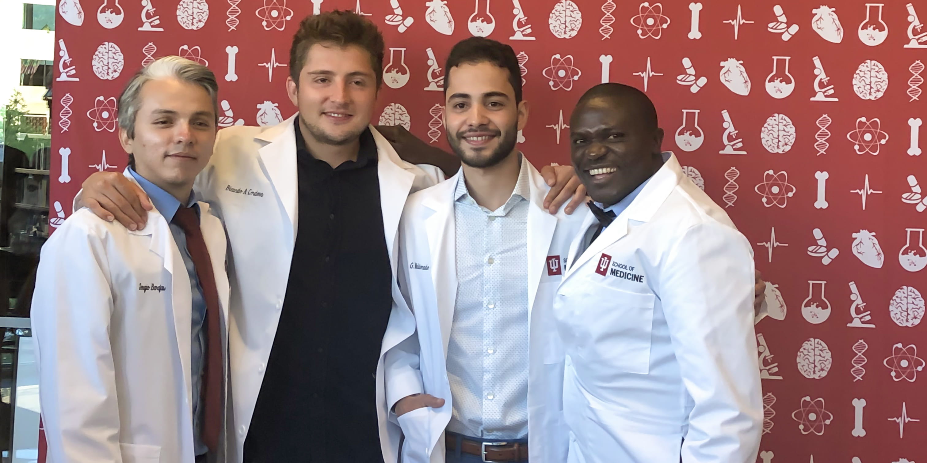 SACNAS students pose for a photo in their white coats
