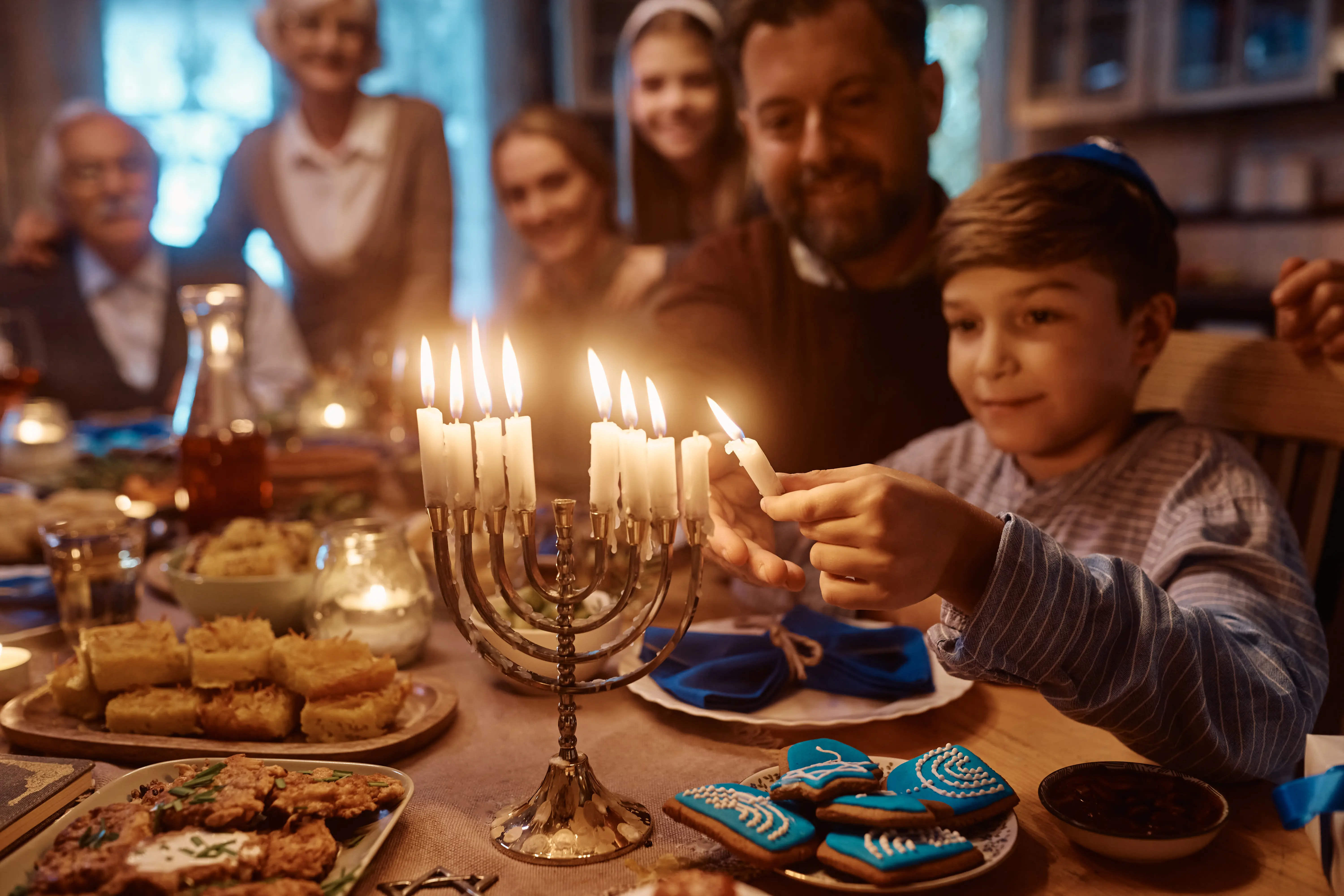 Family lighting menorah candles