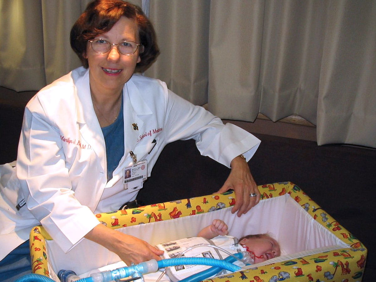 Marilyn Bull with infant in car bed