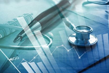 stethoscope, pen and notepad with graphing lines