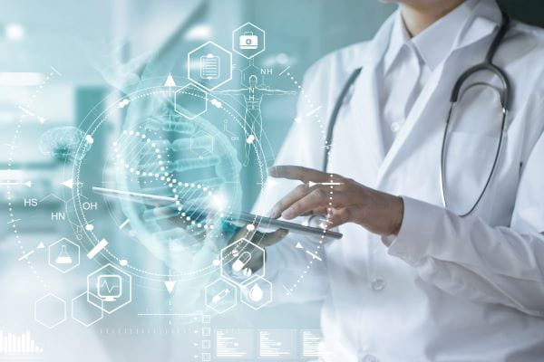 person in white coat using ipad with molecular graphic