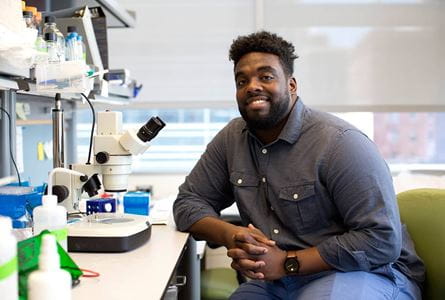 Russell Ledet with a microscope in the lab