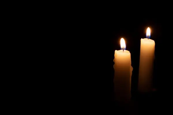 two candles on black background