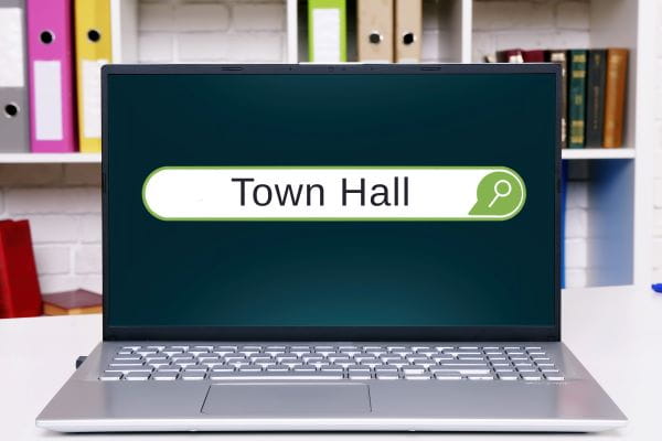 open laptop on table with Town Hall written on screen