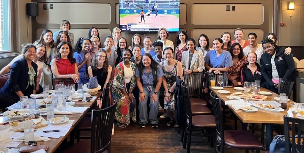 Group of women faculty and trainees pose together at the restaurant.