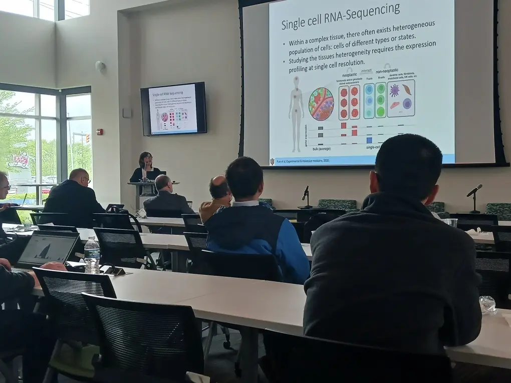 a research speaks in front of projected slides