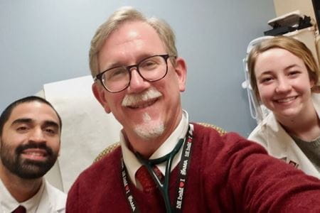 Brad Allen poses with trainees in the clinic. | Photo courtesy of Brad Allen Dr. Brad Allen with IU medical students
