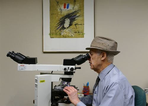 Dr. Lawrence Roth looking into a laboratory instrument