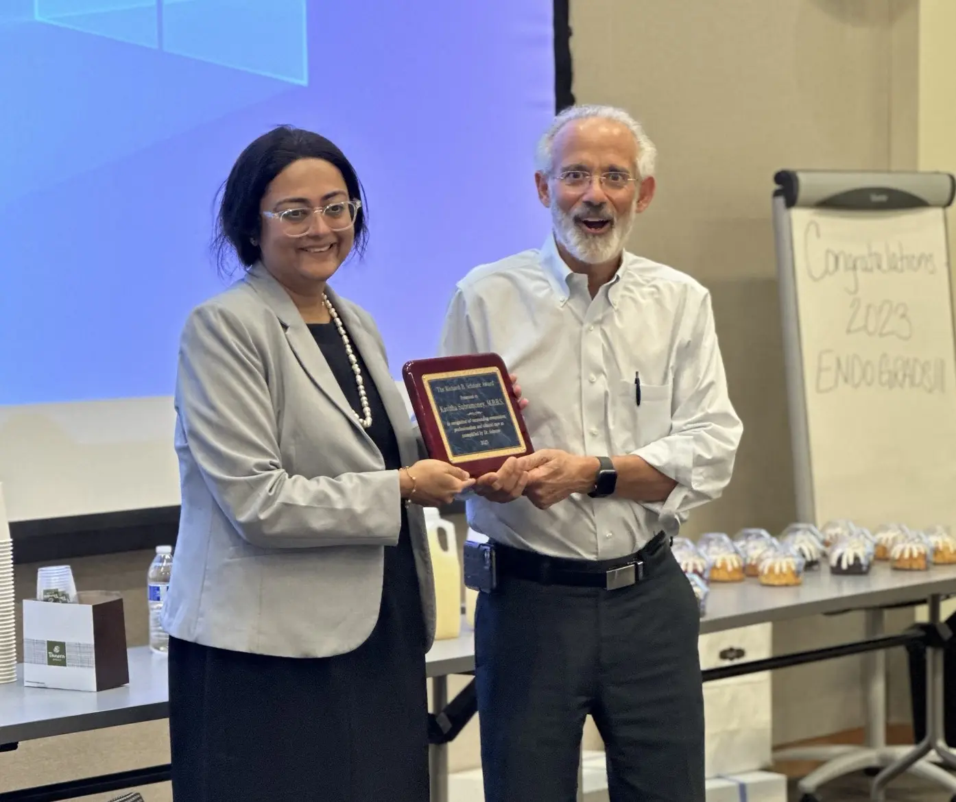 Dr. Subramoney, left, accepts her award.