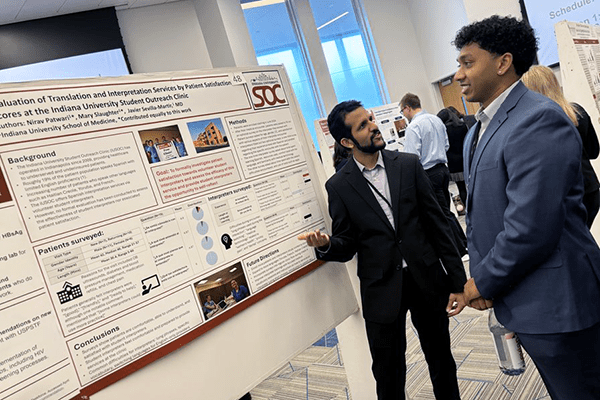IU School of Medicine student talks with another conference attendee about the poster presentation at the 2024 SSRFC Annual Conference.
