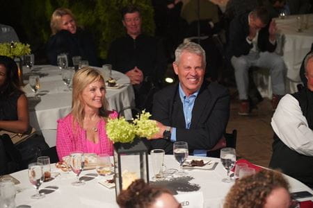 Dr Koch and wife Anita sit outdoors at a white-linen table in formal attire
