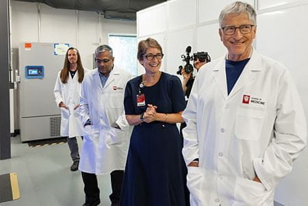 Bill Gates, in foreground wearing an IU white coat, stands in a research laboratory with Tatiana Foroud and two other IU Alzheimer's researchers.