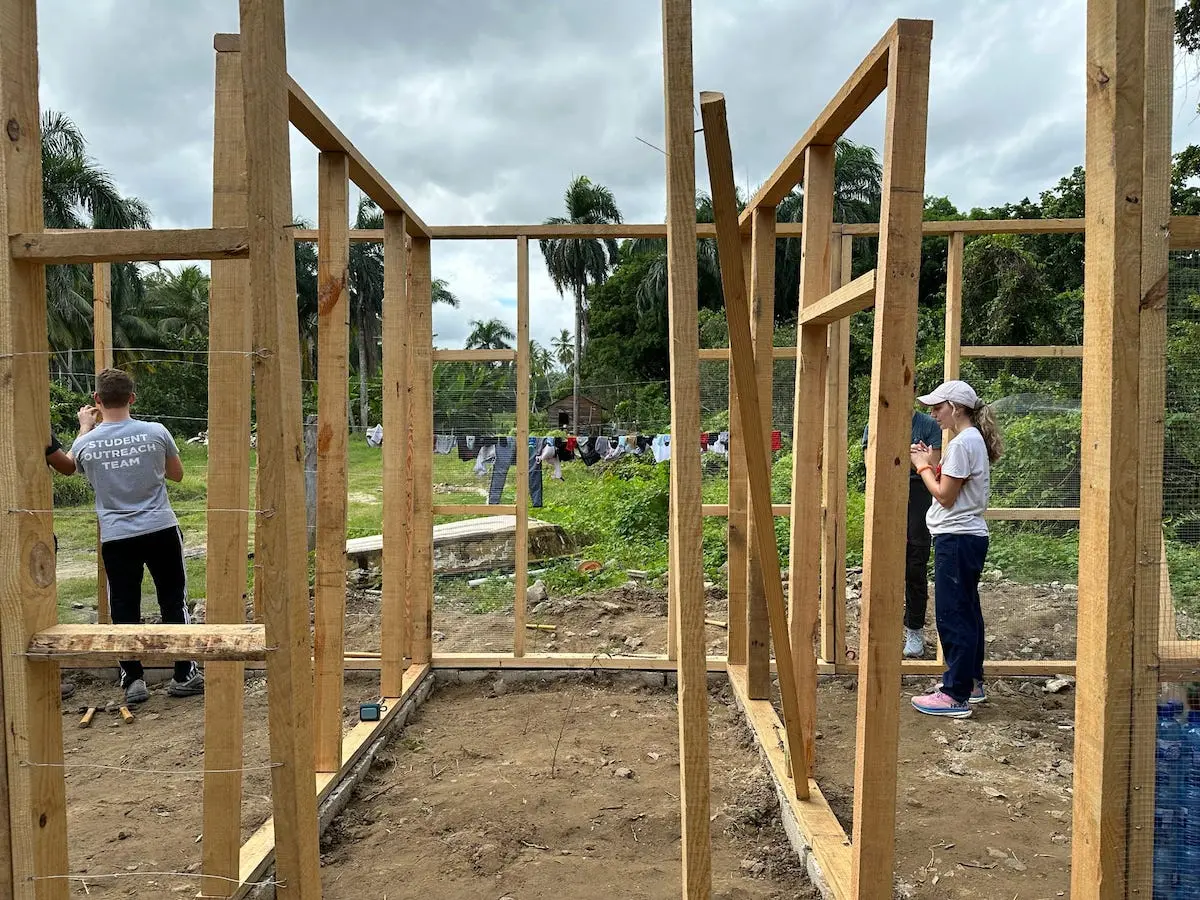 Elizabeth Baker works on the wood frame of a bottle house in the Dominican Republic.