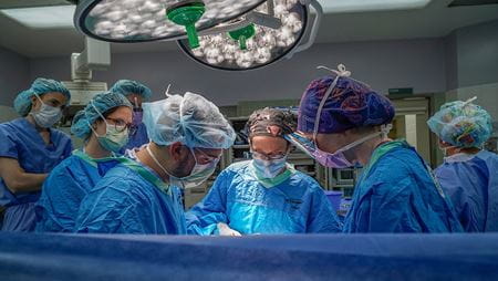 Dr. Kasper leads a minimally invasive gynecologic surgery with trainees present in the OR. Surgical room with physicians in protective gear; Dr. Kasper leads surgery with trainees assisting