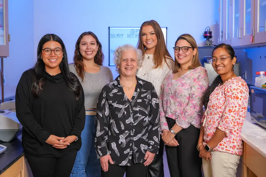 Lilian Plotkin in her lab surrounded by five young women who work in her lab at IU School of Medicine