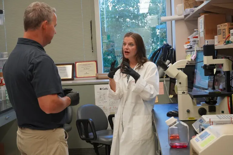 Melissa L. Fishel talking with a lab tour participant