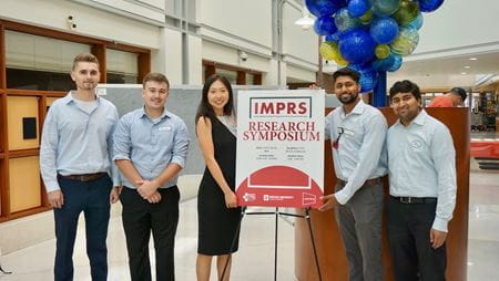Gloria Xue at the IMPRS Research Symposium with classmates from IU School of Medicine—Northwest-Gary. Gloria Xue and classmates from the Gary campus pose by a sign for the IMPRS Summer Research Symposium.