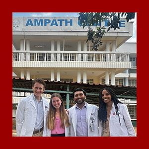 Four medical students stand in front of the AMPATH Centre in Kenya