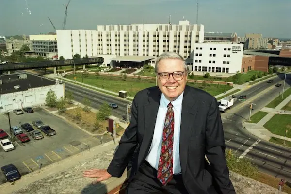 Walter Daly sits on a rooftop atrium overlooking the IUPUI campus in 1995