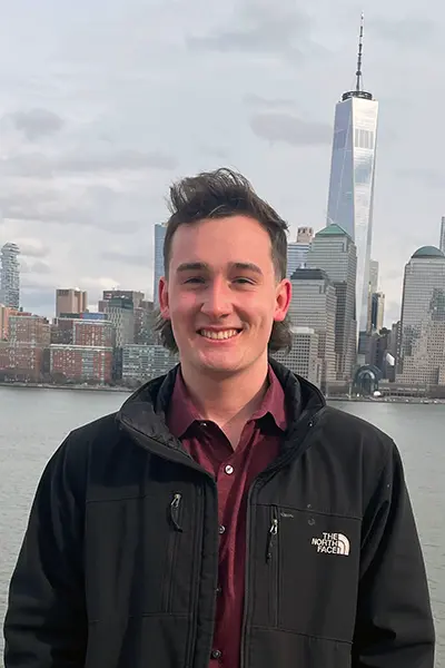Photo of Logan Applewhite in front of water and buildings.