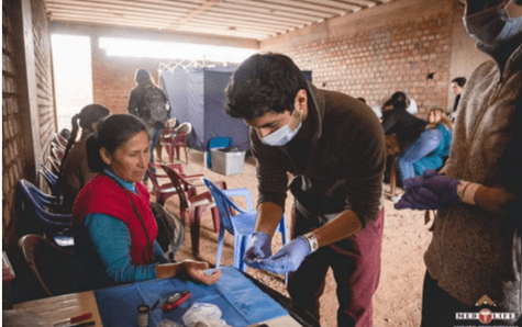 Sebastian Castillo, in protective mask and gloves, works with a female patient at a MedLife clinic in Cusco, Peru