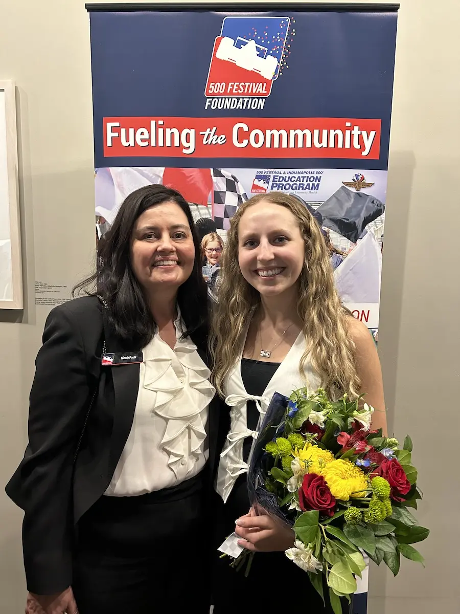 Elizabeth Baker holding flowers, posing with her mentor Nicole Paulk