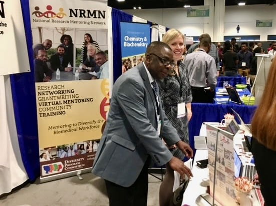 Kola Okuyemi at a table during an NMRN event