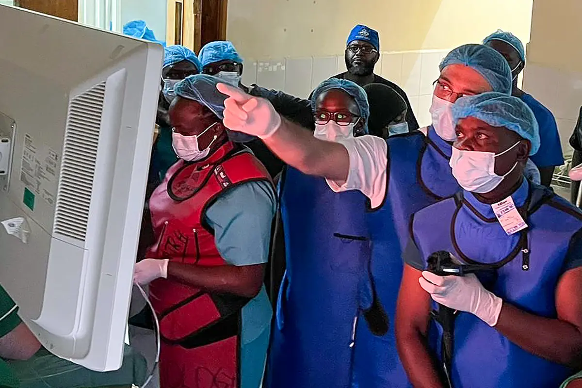 Several people in an operating room with Dr. Al-Haddad pointing to a screen