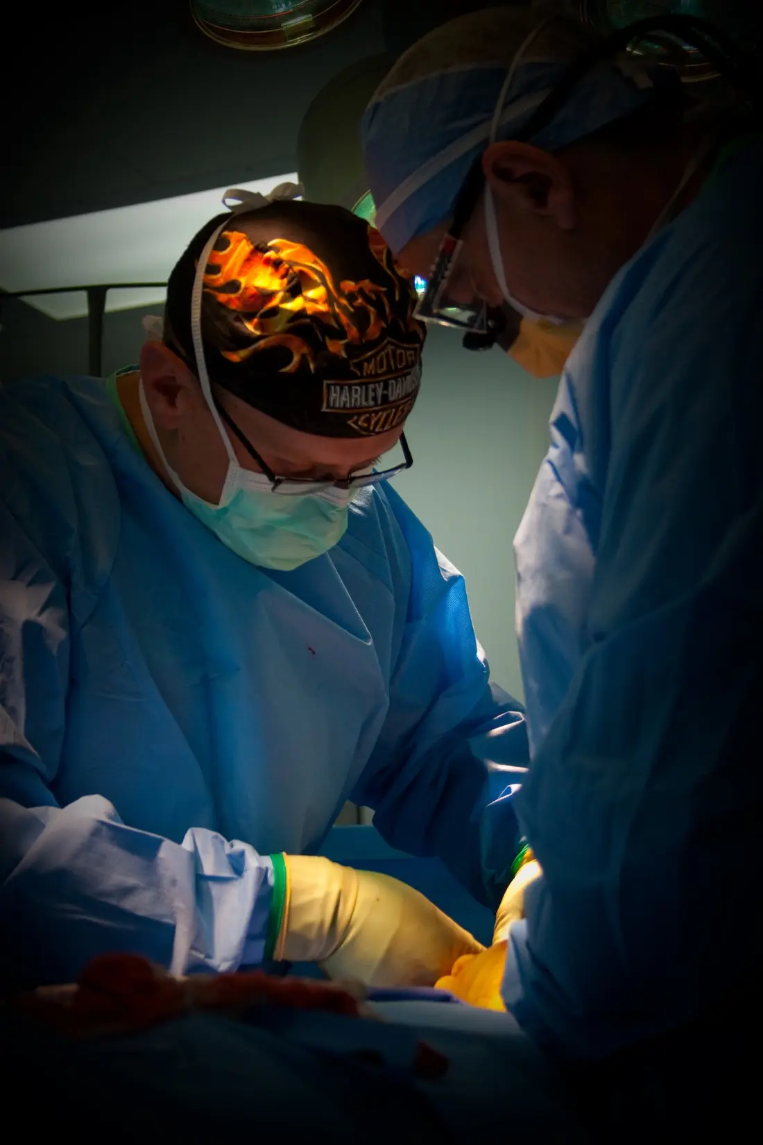 Dr. Ritter performs a surgery wearing surgical scrubs and a Harley Davidson skullcap