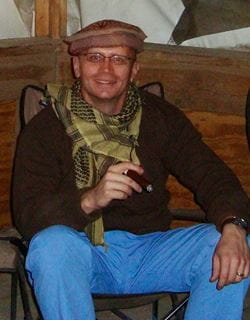 Dr. Ritter smoking a cigar as he sits on the hospital roof, wearing a cap and scarf