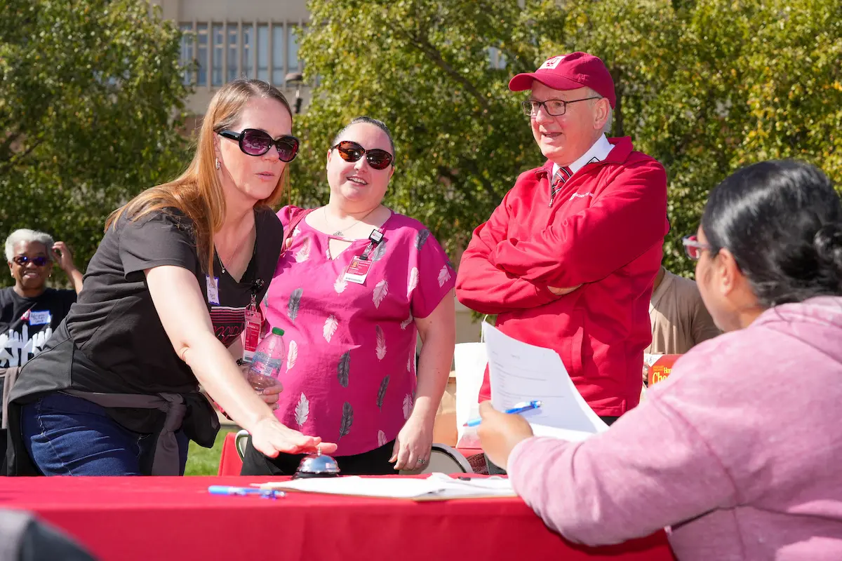 Dean Jay Hess, in red hat, standing by IUSM staff playing a game