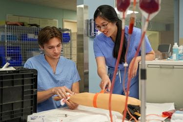 Wen Danh works with a student in the simulation lab