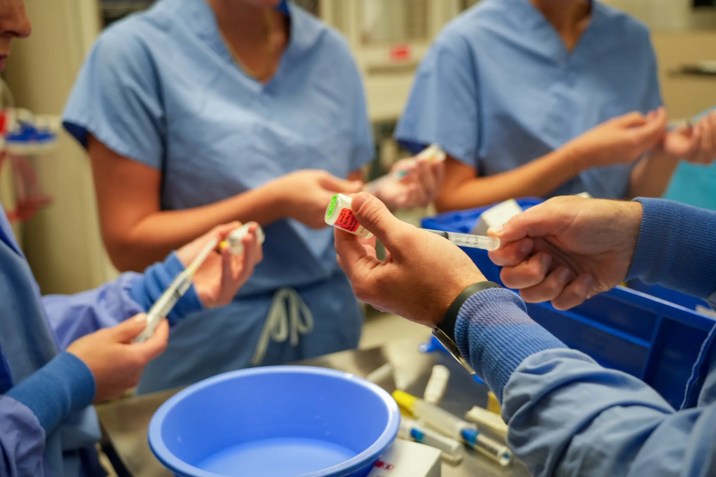 Closeup image of students practicing drawing liquid from a medication vial